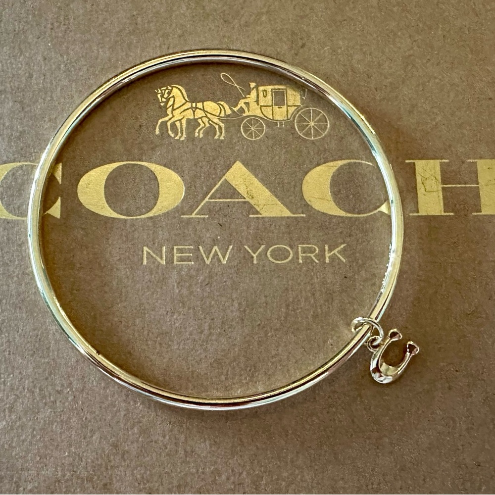 Coach Gold-tone Skinny Bangle Bracelet with Dainty Signature C Dangling Charm.